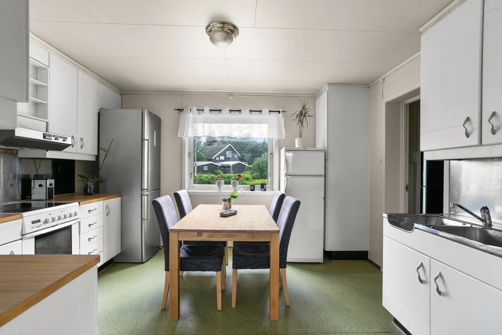 Kjøkkenet har avsatt plass til frittstående hvitevarer som komfyr, oppvaskmaskin og kjøleskap. Galleribilde