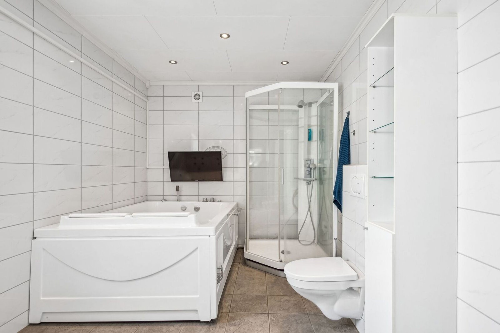 Badet har i tillegg lys innredning, veggmontert toalett og dusjkabinett. Galleribilde