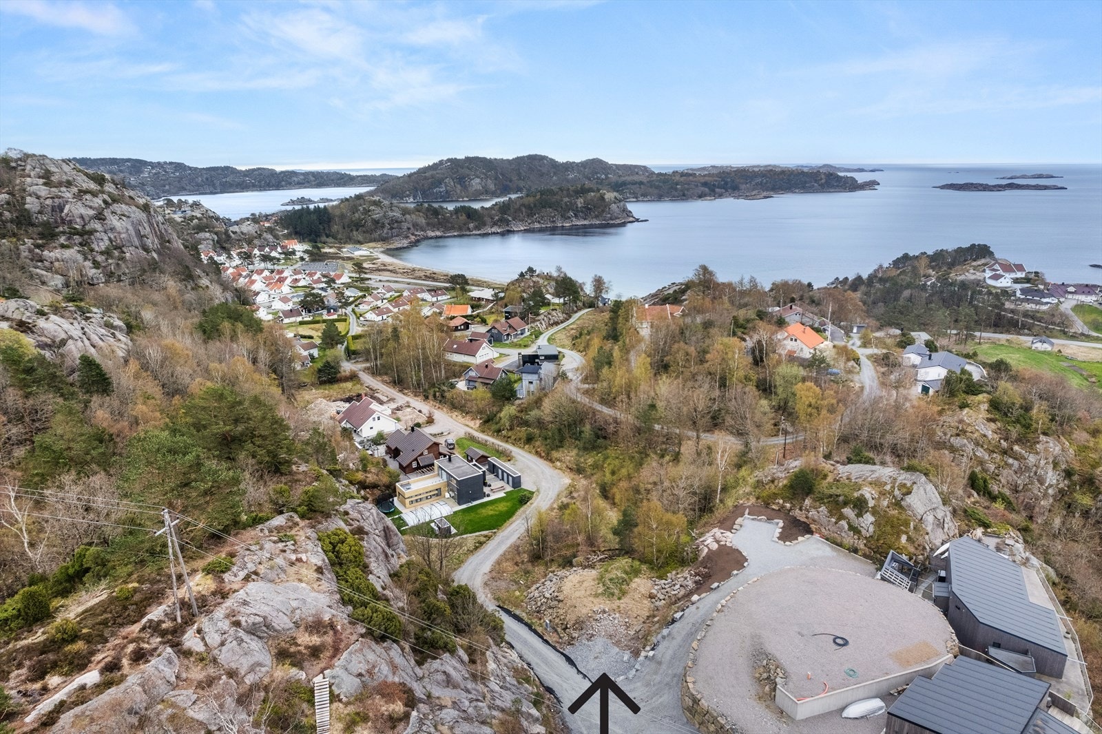 Tomten ligger midt i bildet langs veien. Galleribilde