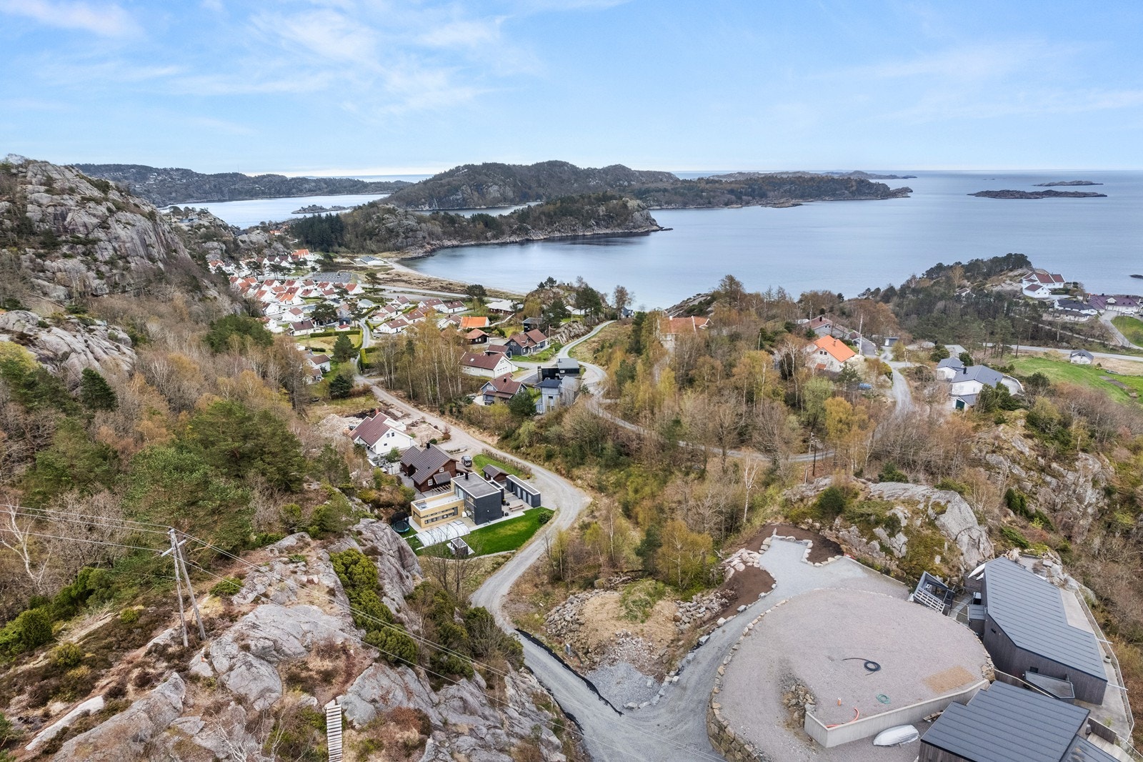Tomten ligger midt i bildet langs veien. Galleribilde
