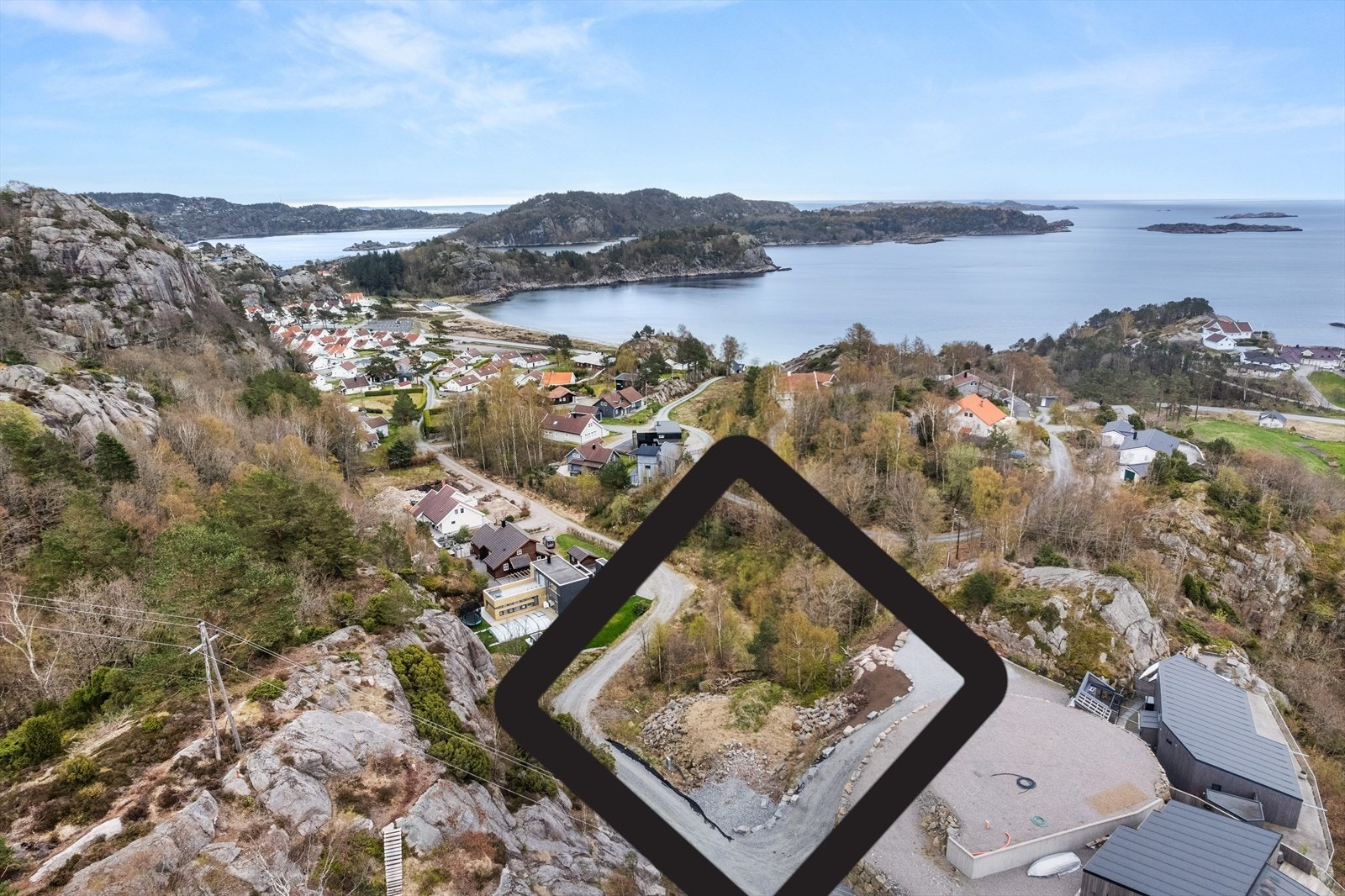 Tomten ligger midt i bildet langs veien. Galleribilde