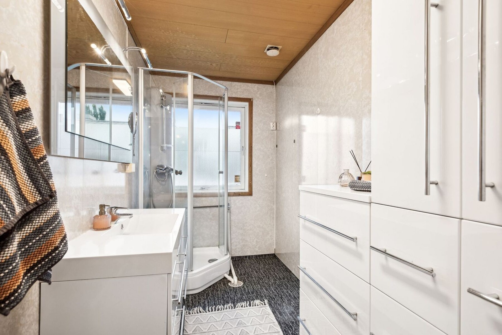 Baderommet er utstyrt med vegghengt servantskap, ett-greps armatur, dusjkabinett og opplegg for vaskemaskin, med adskilt WC-rom. Galleribilde