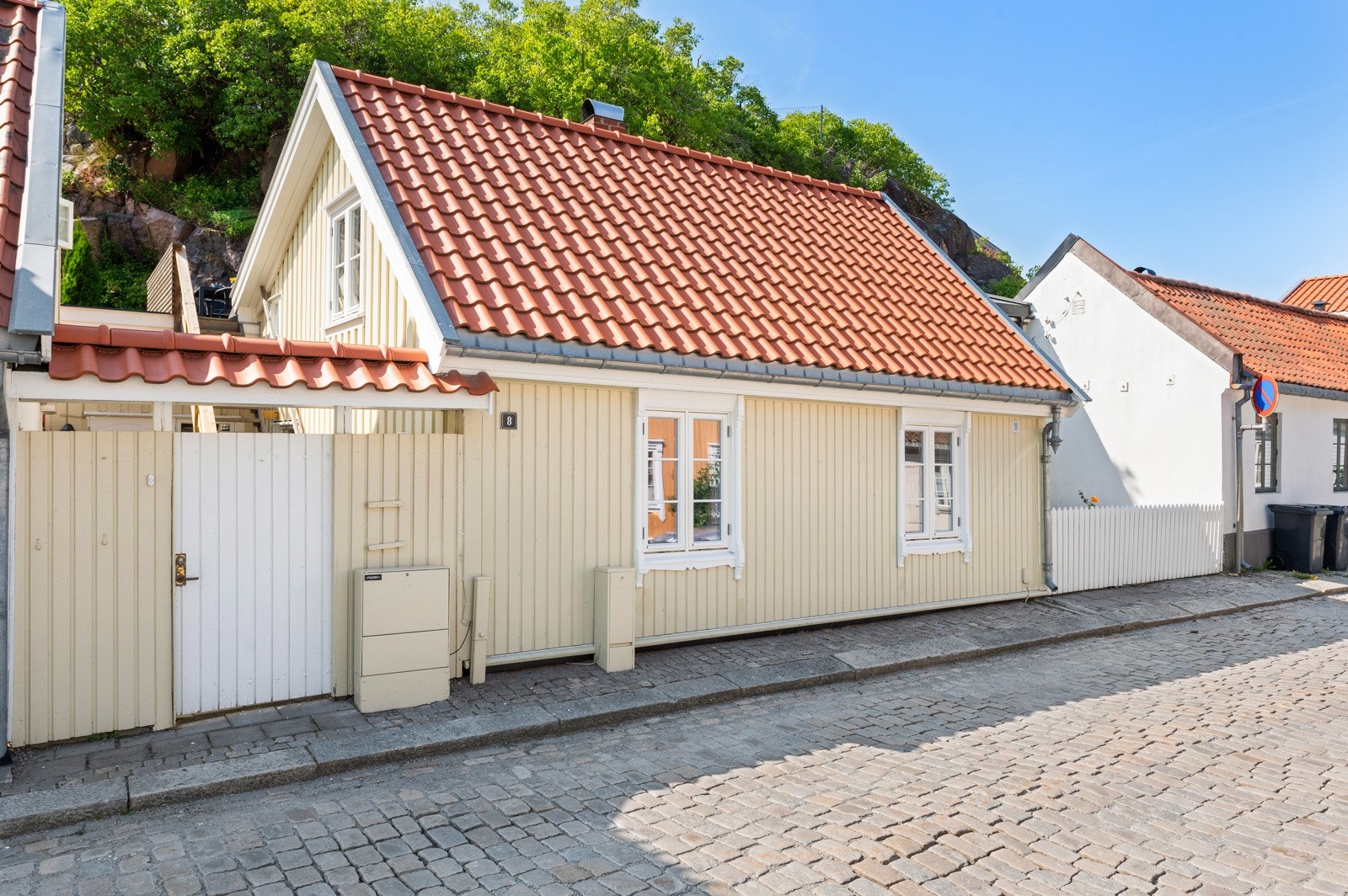 Sjarmerende bolig sentralt beliggende i sjarmerende omgivelser med kort gangavstand til både byen og sjøen Inngang til boligen via hvit port. Gjerdet langs med gate er mulig å åpne for adkomst til uteplass. Galleribilde
