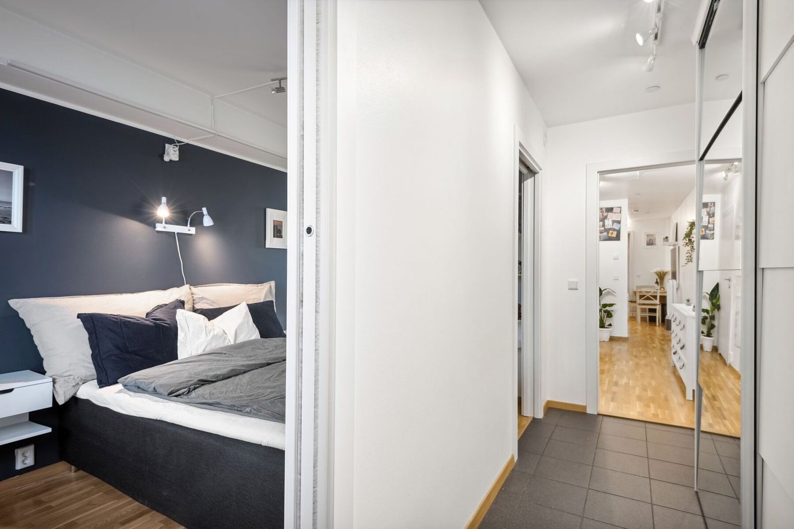 Rett fra entrèen kommer du til et lunt og stilrent soverom med to dører som gir praktisk tilgang fra både gang og stue. Galleribilde