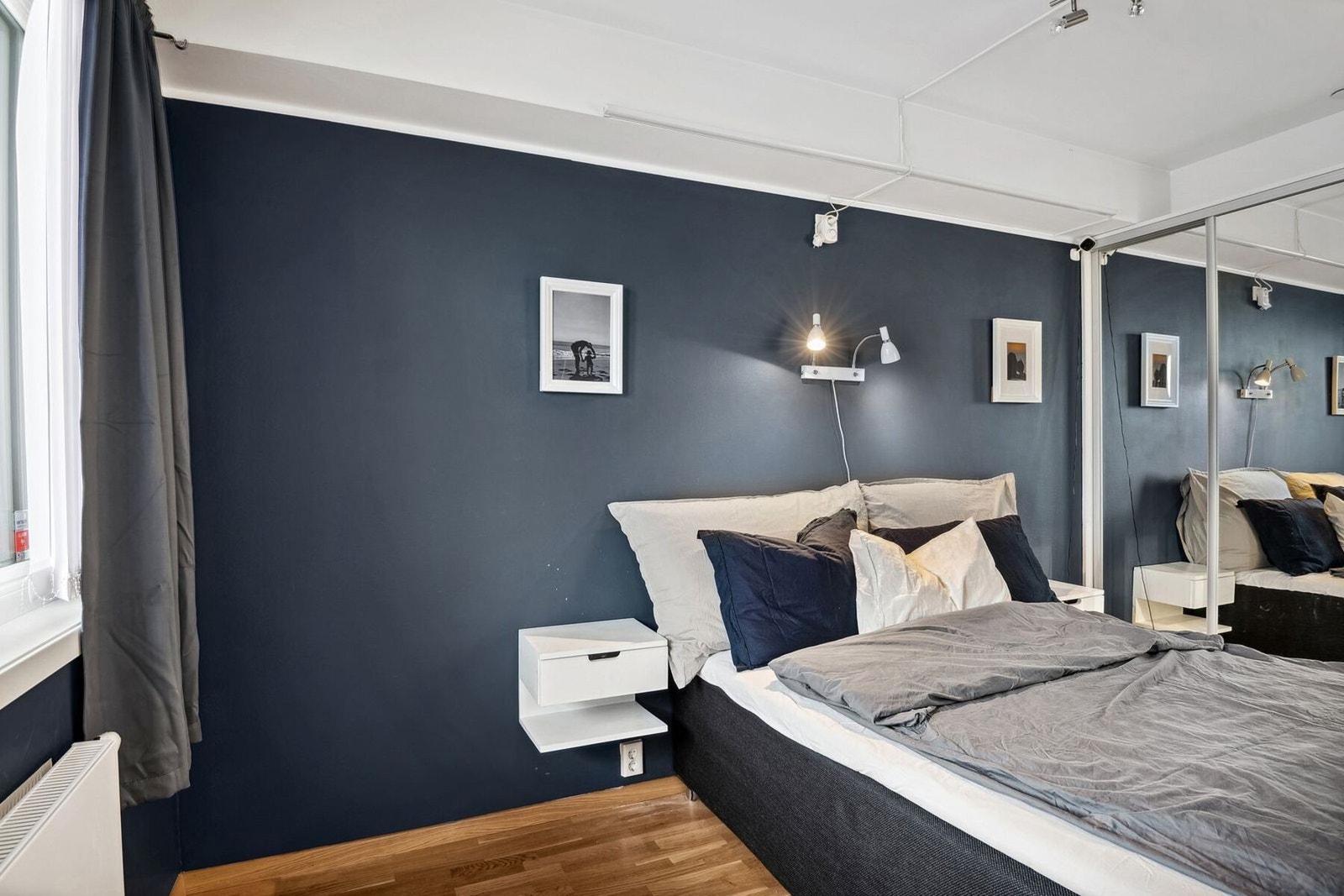 Lunt soverom med mørk vegg, speilgarderobe og godt lys - perfekt for avslapning. Galleribilde