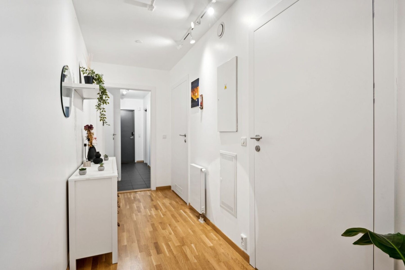 Romslig og lys gang med pene detaljer og god plass til oppbevaring, gir et varmt velkommen. Galleribilde