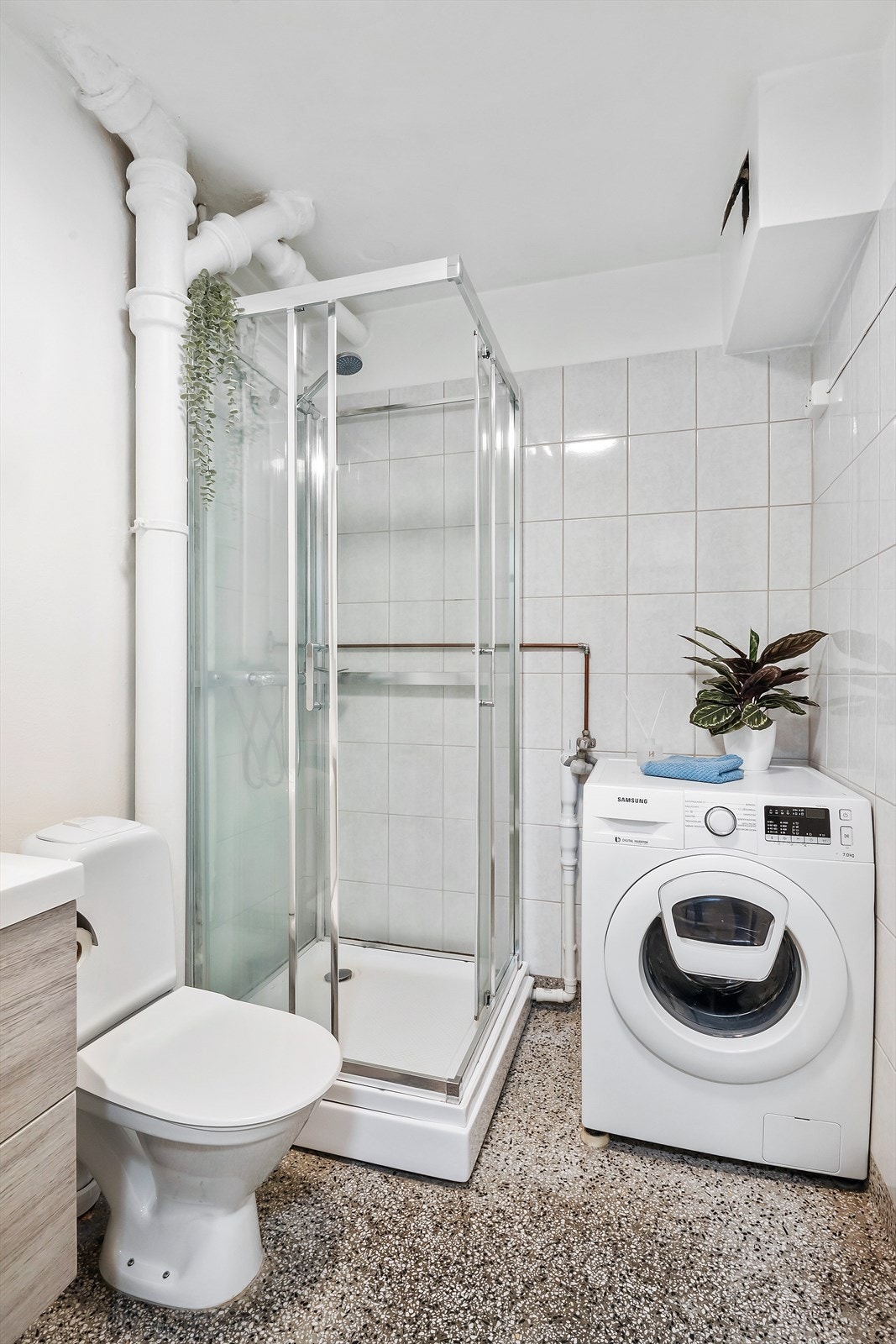 Romslig bad med opplegg for vaskemaskin, toalett og dusjkabinett Galleribilde