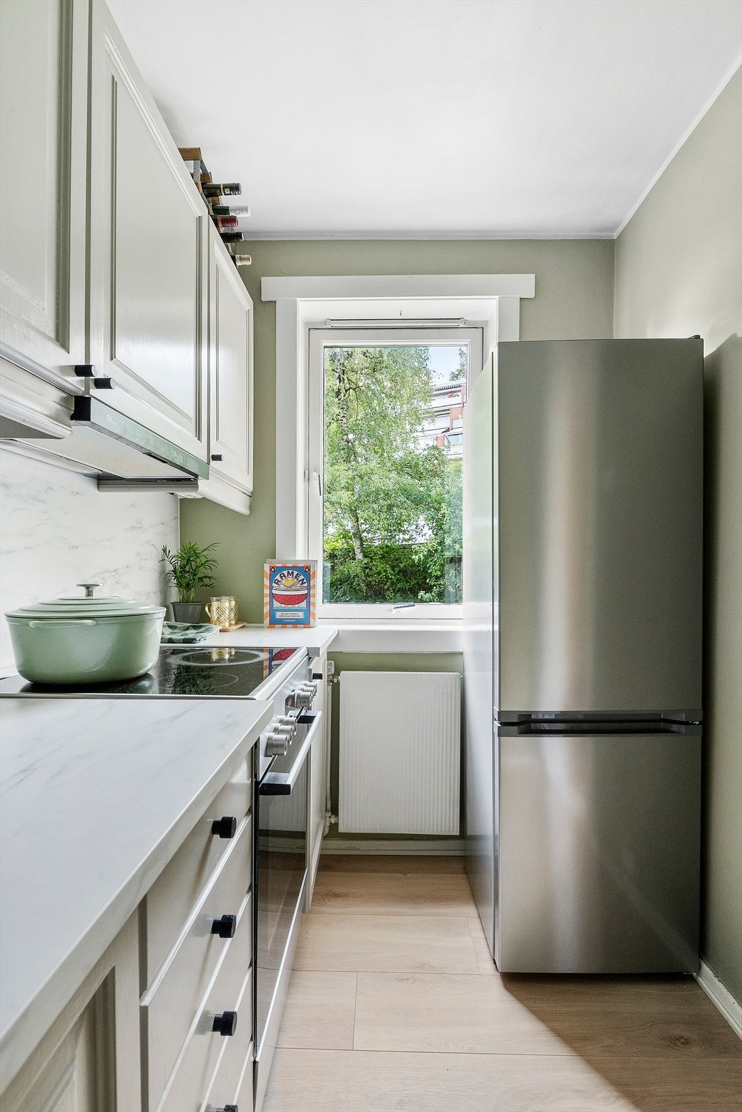 Hyggelig, adskilt kjøkken med 1-stavs laminat, malte veggflater og vindu Galleribilde