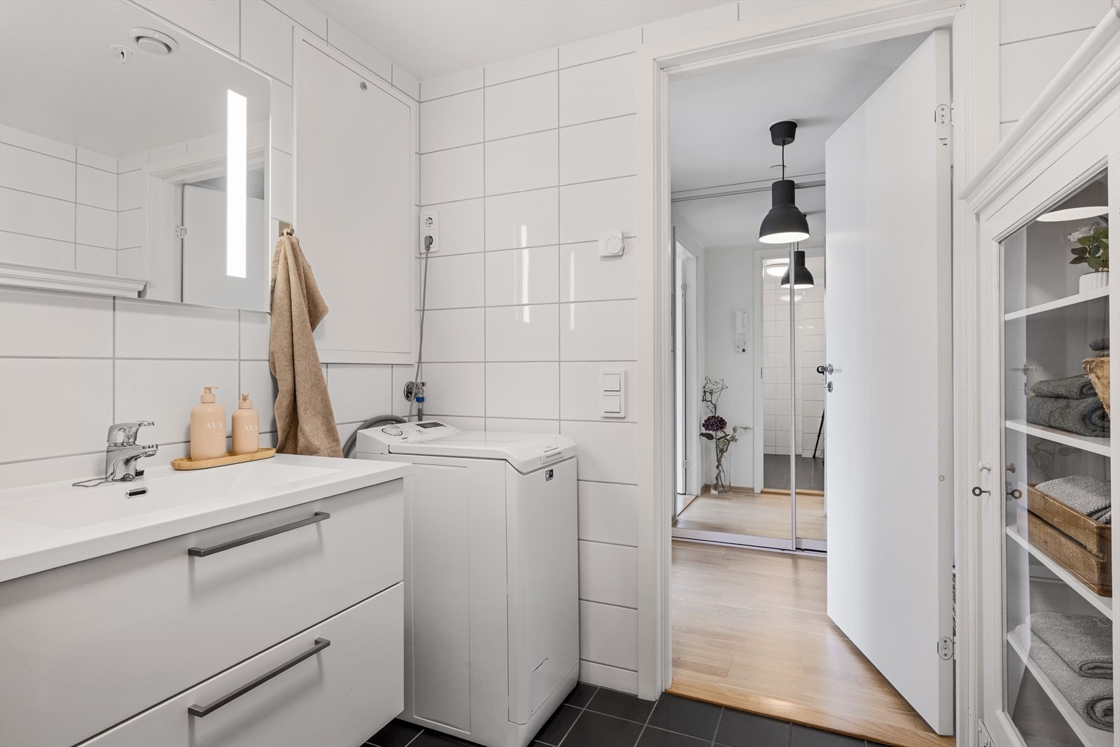 Lekkert innredet med dusjnisje med glassdør, vegghengt wc, og heldekkende servant med tilhørende underskuffer med hvite glatte fronter. Galleribilde