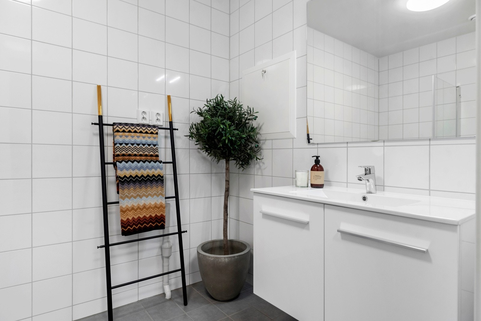 Rommet er utstyrt med vegghengt klosett, opplegg for vaskemaskin, servant med skap og dusjhjørne med innfeltbare glassdører. Galleribilde