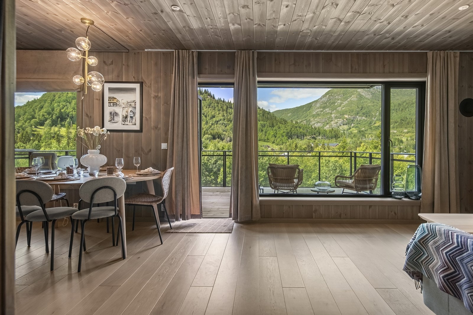 Fra entreen er det dør med store glassfelt inn til et stort, innbydende og romslig oppholdsrom med stue i den ene enden og kjøkken i den andre. Galleribilde