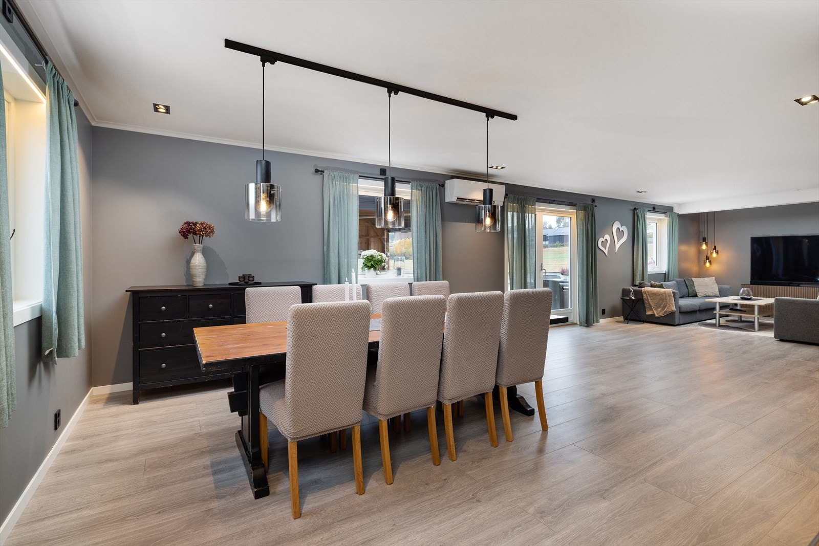 Mellom stue og spisestue er det moderne åpen løsning, som gjør det enkelt å innrede med både sofagruppe og et stort spisebord. Galleribilde