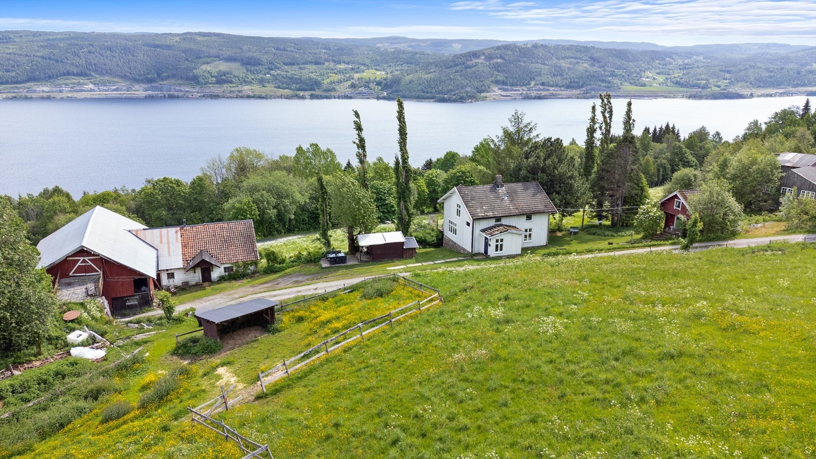 Hovedhuset ligger lunt til på tomten, med vakker innramming av natur og beplantning. Galleribilde