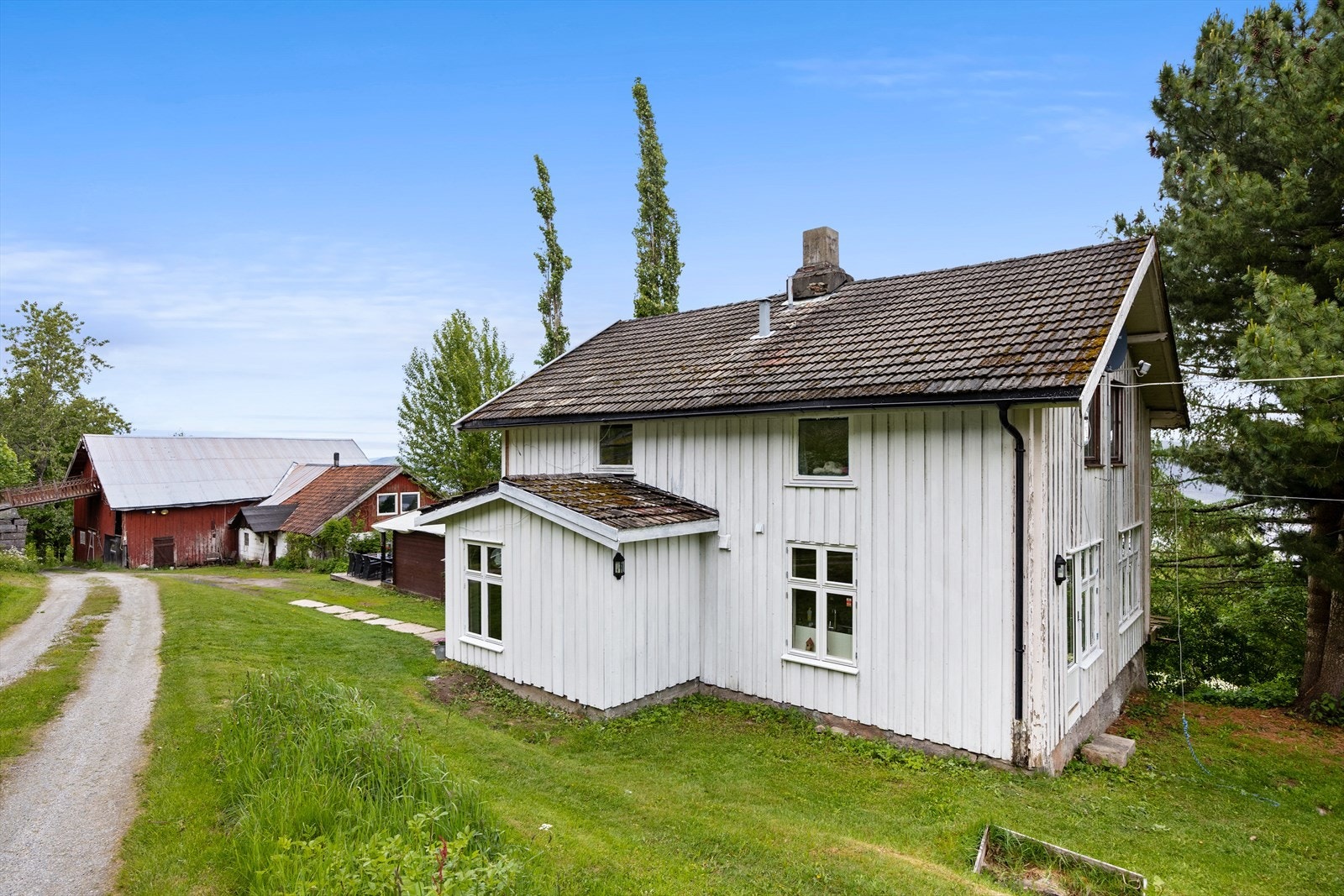 Sjarmerende hovedhus omgitt av frodige grøntområder og idyllisk tun. Galleribilde
