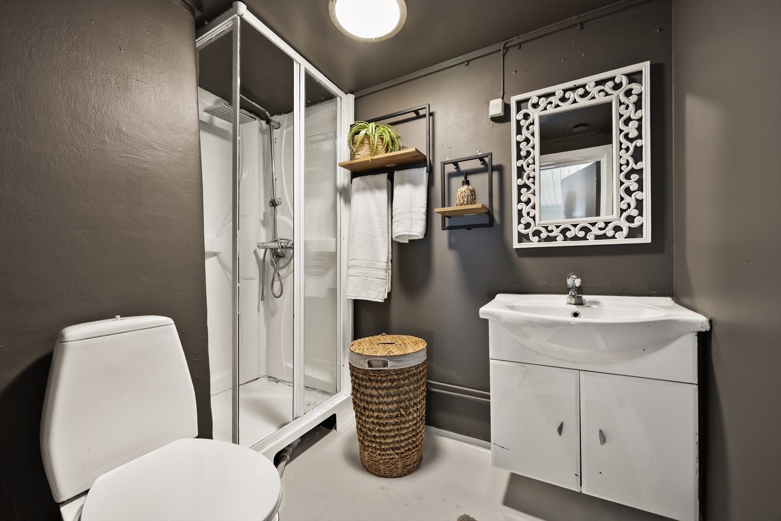 Bad med innredning med nedfelt servant, gulvstående toalett og dusjkabinett. Galleribilde