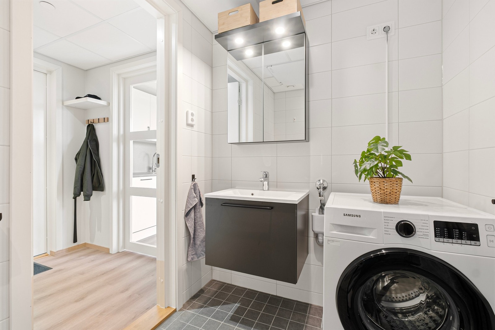 I tillegg er det vegg hengt innredning med tilhørende speil og opplegg for vaskemaskin Galleribilde