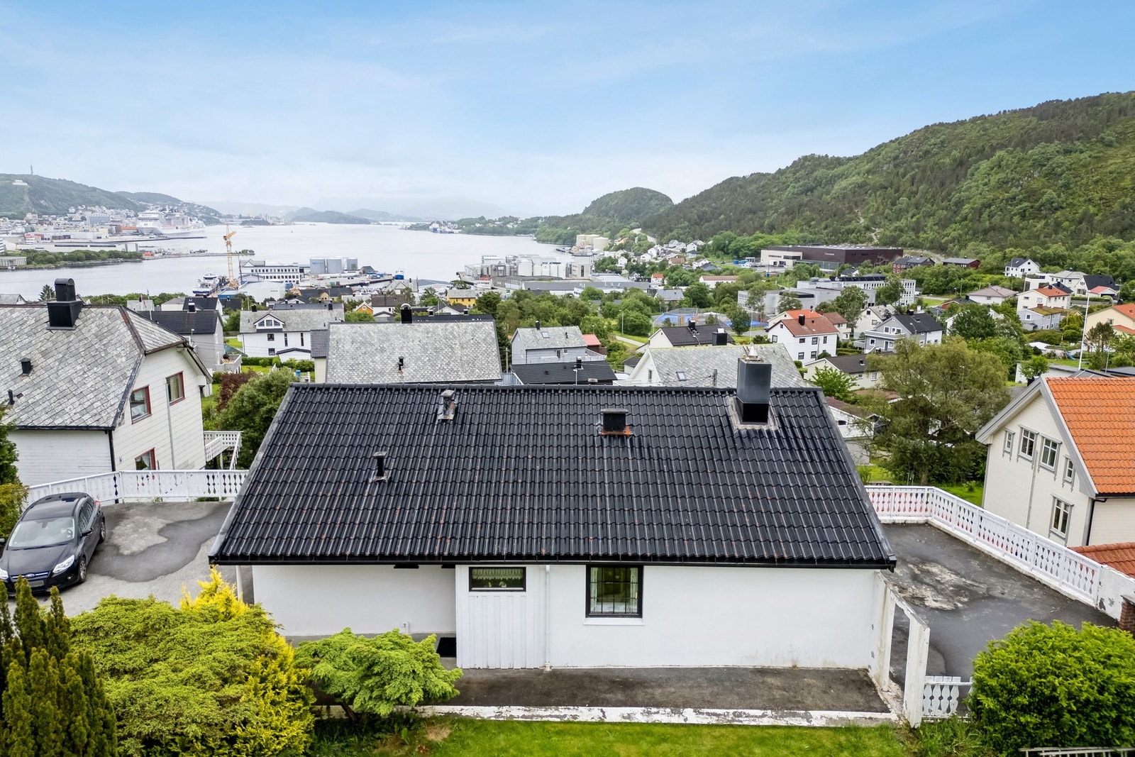 Flott utsikt mot Aspevågen, Fjellstua skimtes i venstre hjørne. Parkeringsplasser på nordsiden av huset. Galleribilde