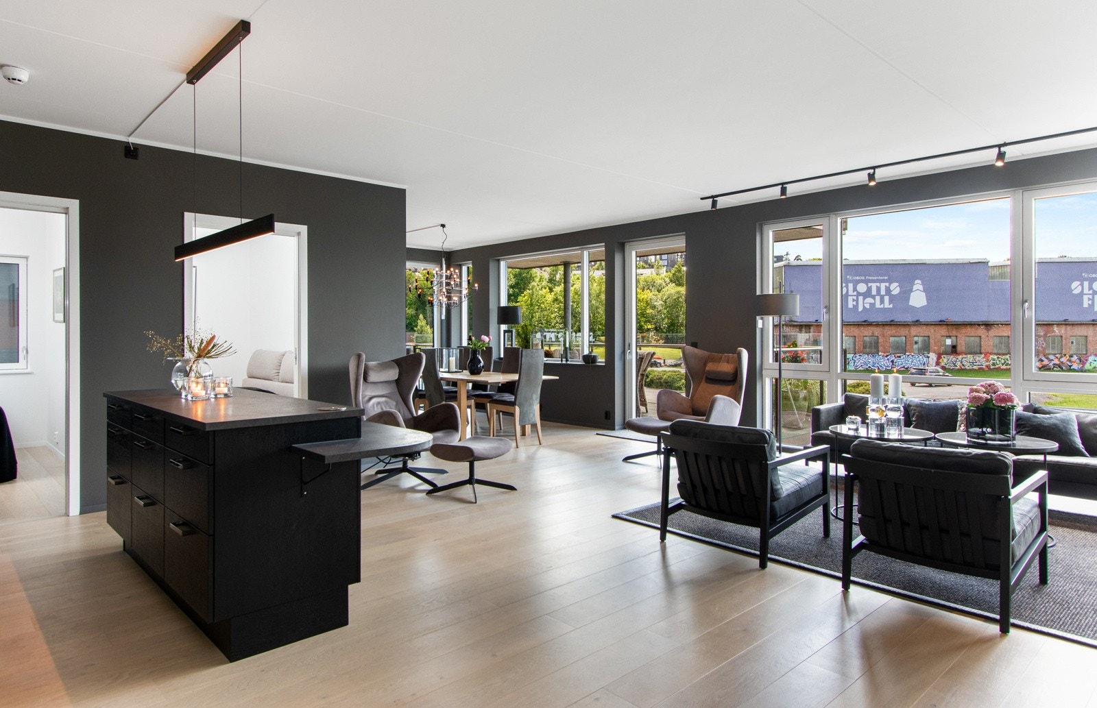 På gulvet er det lagt lys 1-stavs parkett med varme, mens veggflatene er malt i en mørk og delikat gråtone. Galleribilde