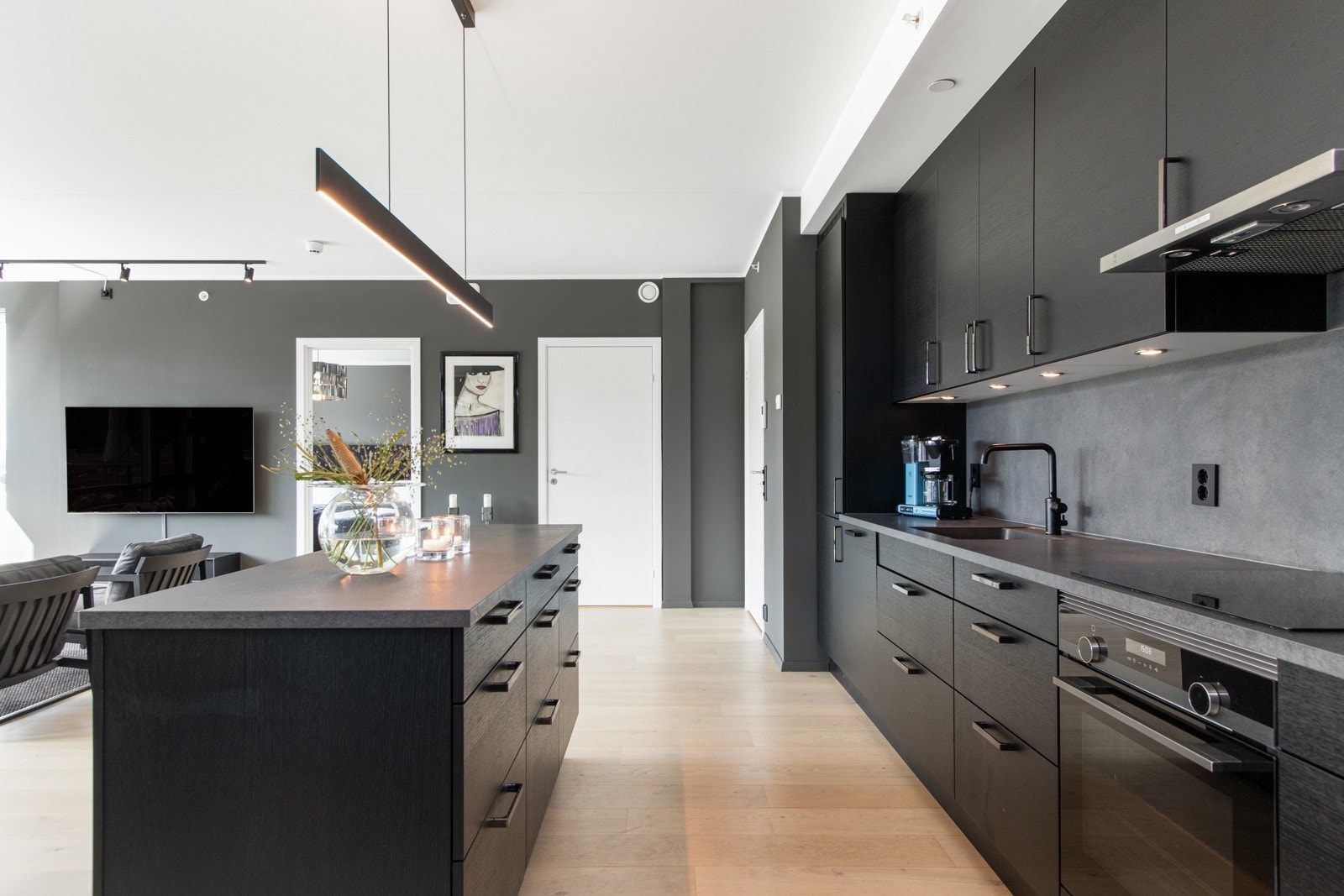 Innredningen har sorte, glatte fronter og benkeplate av laminat med nedfelt oppvaskkum i sort. Galleribilde