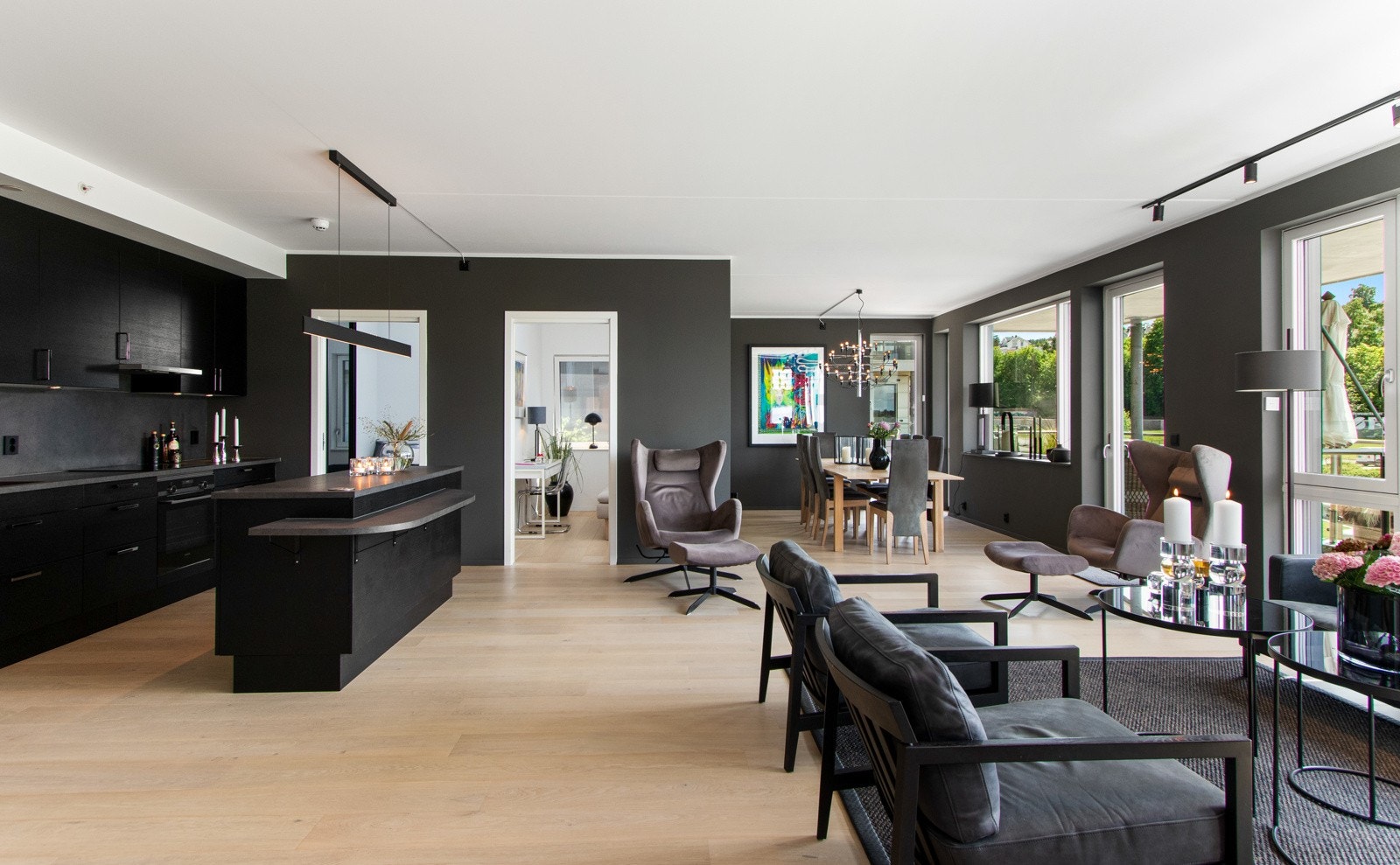 Innenfor entreen danner stuen og kjøkkenet et virkelig flott allrom, med fantastiske lys- og utsiktsforhold via store vinduer i tre retninger - her føles det som om man sitter på sjøen. Galleribilde