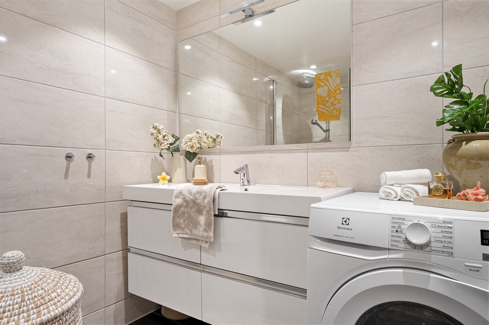 Badet har godt med lys, delikat flisekombinasjon og opplegg for vaskemaskin/tørketrommel. Galleribilde
