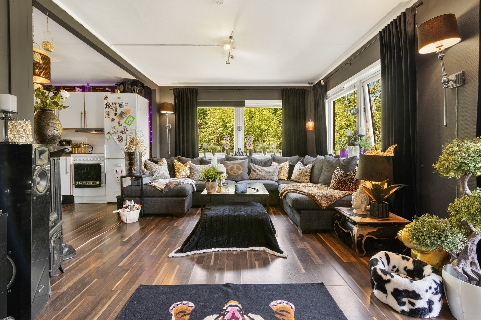 Romslig stue med store vindusflater i åpen løsning med kjøkkenet. Galleribilde