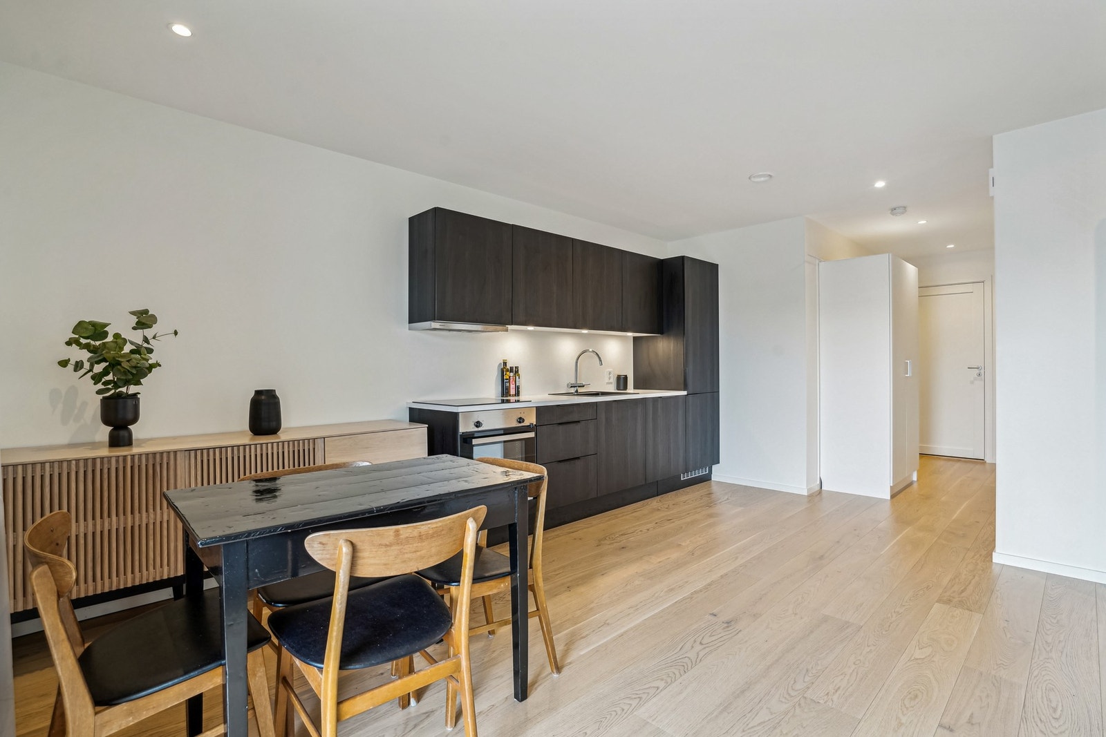 Lekkert kjøkken med mørke fronter og laminat benkeplate. Galleribilde