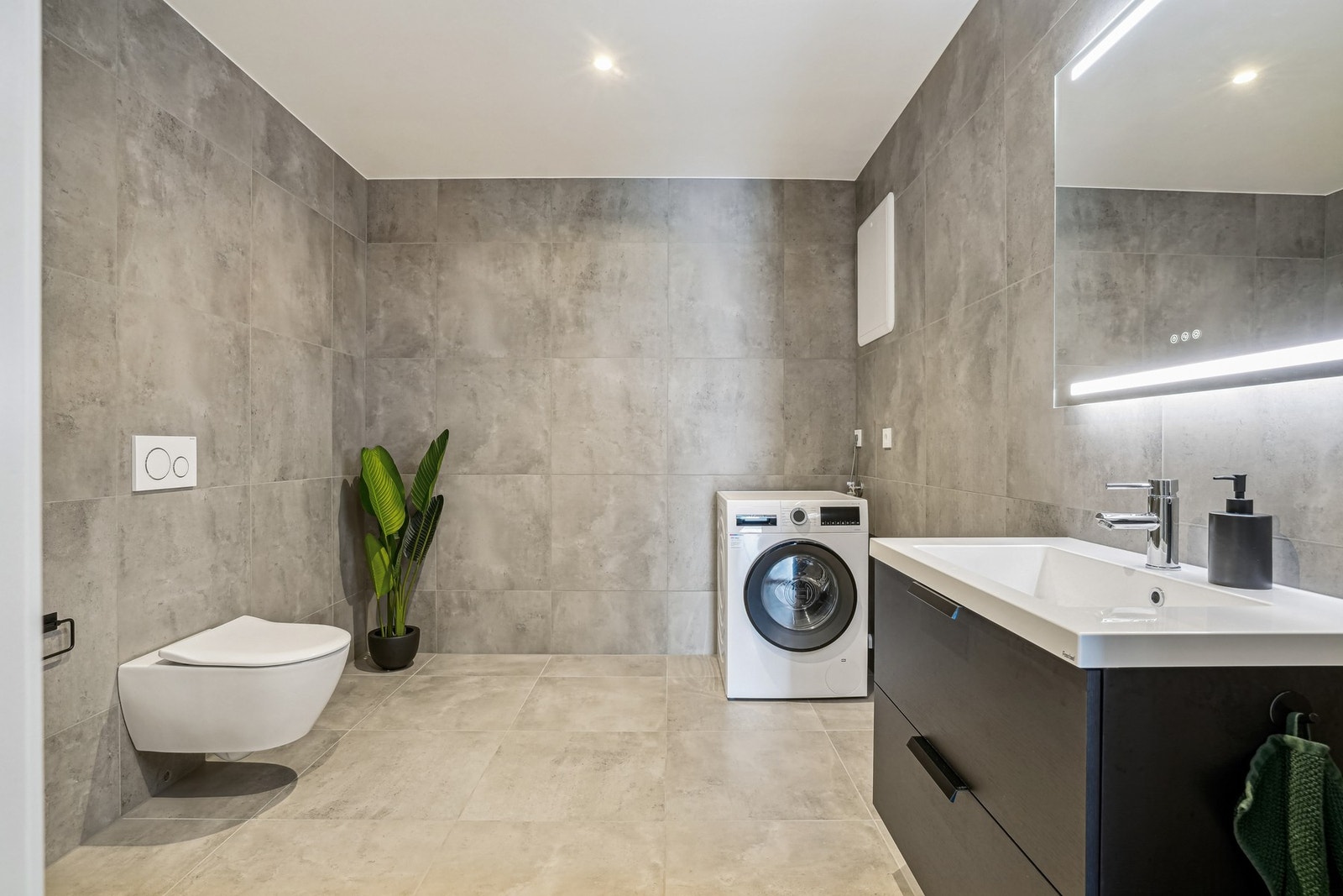 Lekkert helfliset bad/vaskerom med fjernvarme i gulvet. I hvit himling er det ledspotter med dimming. Galleribilde