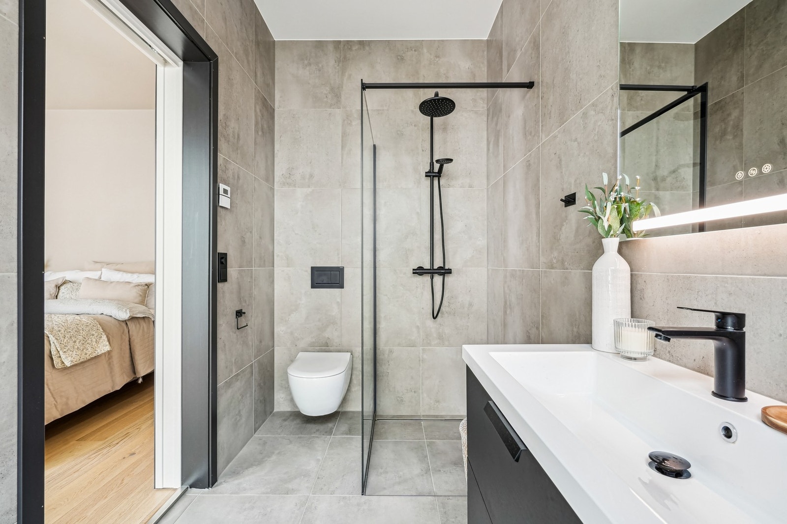 Delikat helfliset bad med vannbåren gulvvarme. Innredet med vegghengt toalett, dusjhjørne med regnfallsdusj - Galleribilde