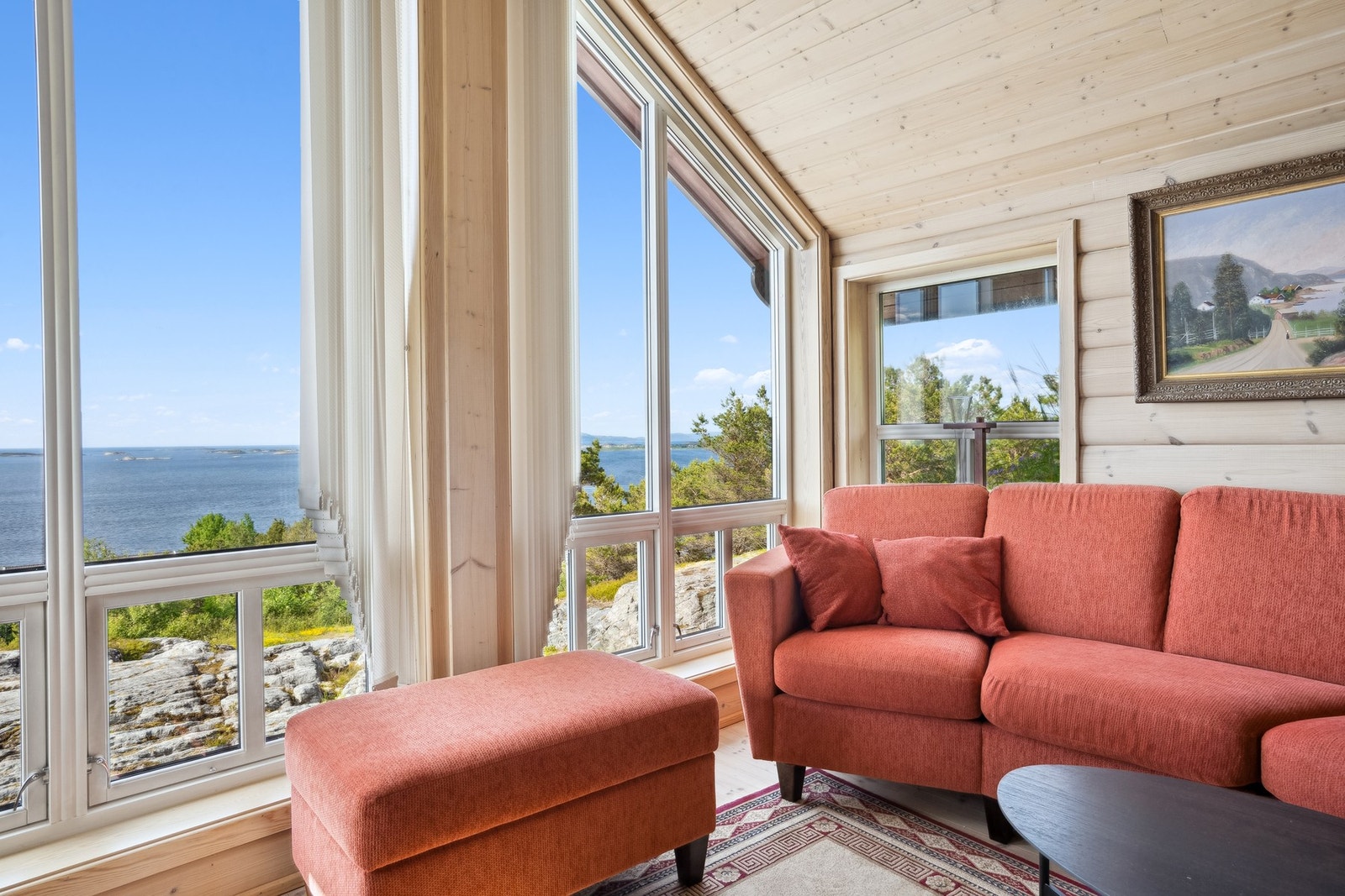 Store vindusflater som strekker seg helt opp til taket gir rikelig med lys og vakker utsikt over sjøen. Galleribilde