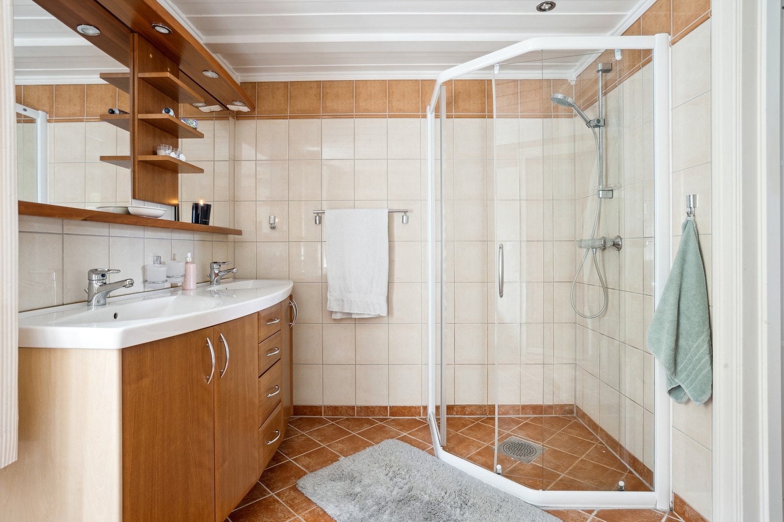 Badene er utstyrt med dusjvegger, dobbelservant og oppbevaringsløsninger. Galleribilde