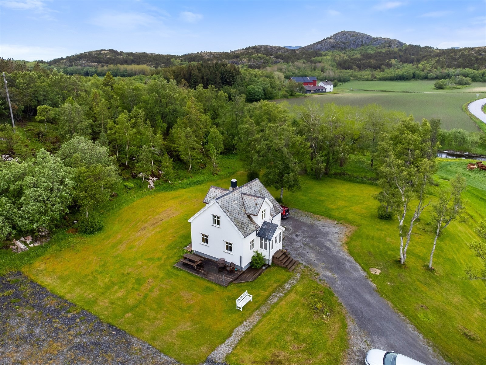 Tomten er romslig og pent opparbeidet med store plenområder, trær, busker og naturlig vegetasjon. Galleribilde