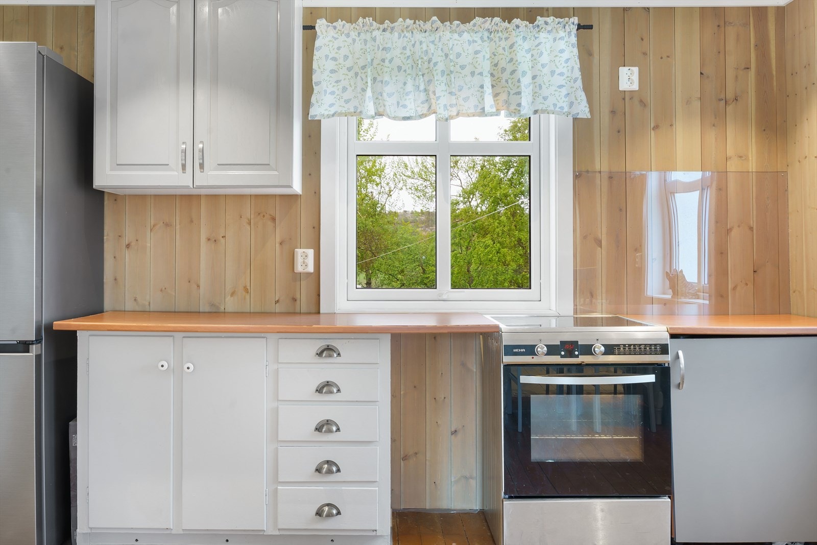 For å beskytte veggen ved vask og komfyr er det montert plexiglass både over vask og ved vinduet ved komfyrplasseringen. Galleribilde