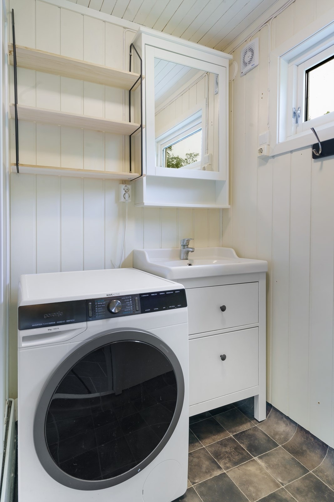 Servantskap med heldekkende servant og speilskap fra 2021. Badet har også opplegg for vaskemaskin. Galleribilde