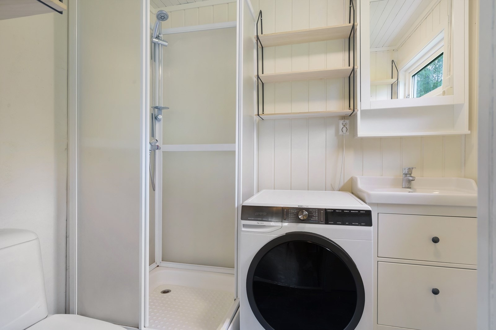 Badet, som ligger i første etasje, ble delvis oppgradert av tidligere eier rundt 2012. Rommet har gulvbelegg og vegger kledd med kombinasjon av baderomsplater og malt panel, mens himlingen er kledd med trepanel. Galleribilde