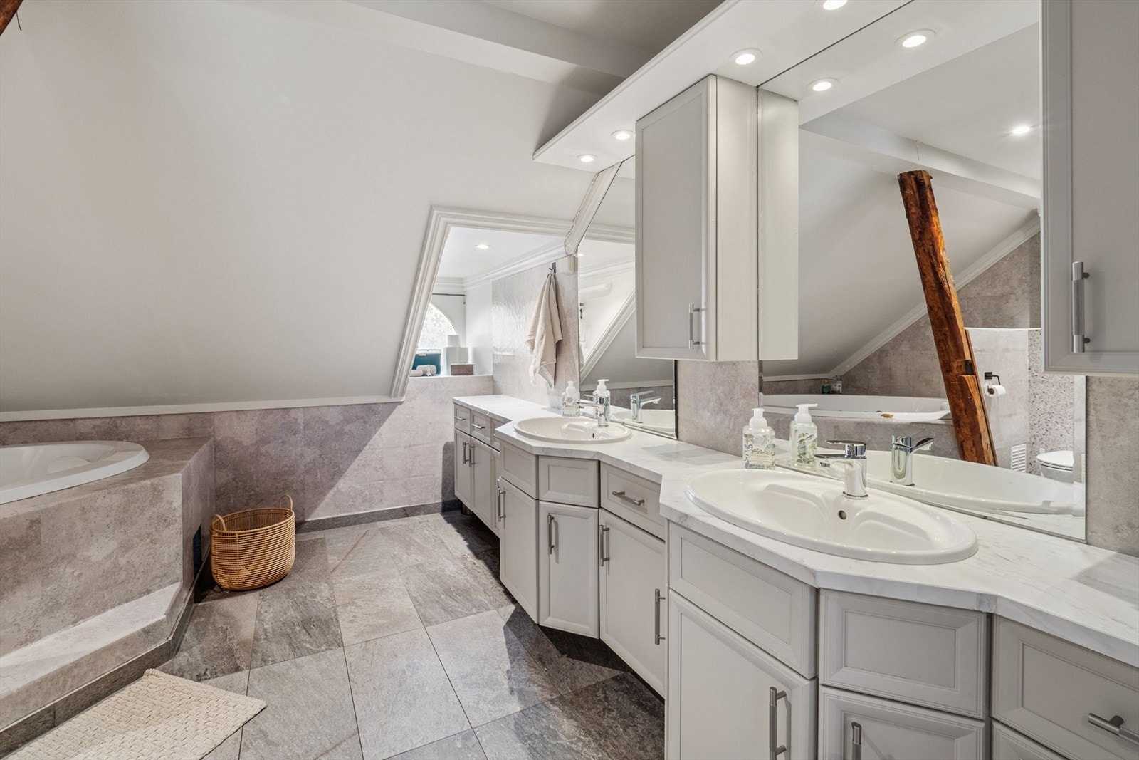 Romslig bad med dobbel servant, boblebadekar, stor dusj og vegghengt toalett. Galleribilde