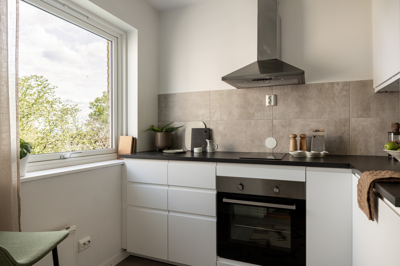 Kjøkkenet ligger i et eget rom i naturlig tilknytning til stuen. God og moderne standard med enstavs laminat på gulv og glatte malte overflater. Galleribilde