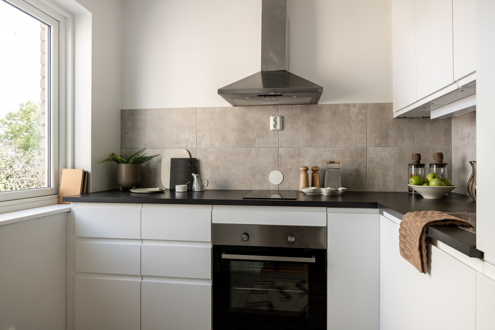 Moderne Ikea-kjøkken fra 2016 med god skap- og benkeplass. Innredningen har hvite glatte fronter og laminert benkeplate med nedfelt oppvaskkum. Både fint og praktisk med flotte fliser i benkeryggen og belysning under overskapene. Galleribilde