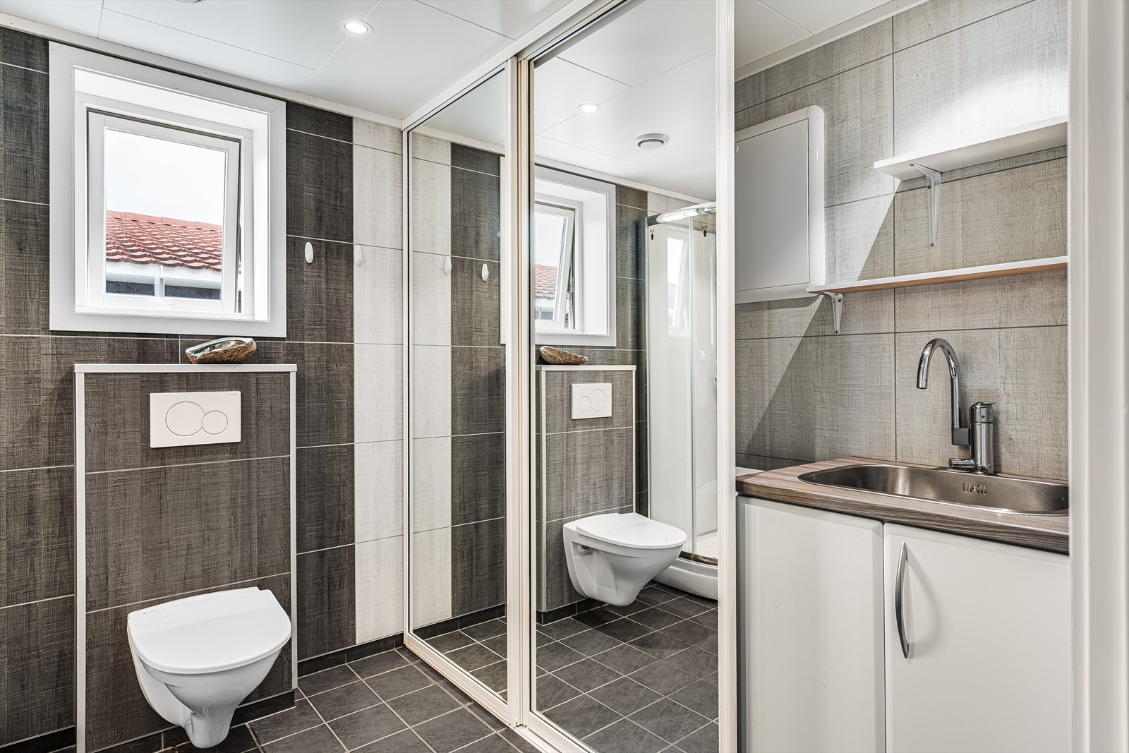 Det er montert et vegghengt toalett og dusjkabinett. Galleribilde