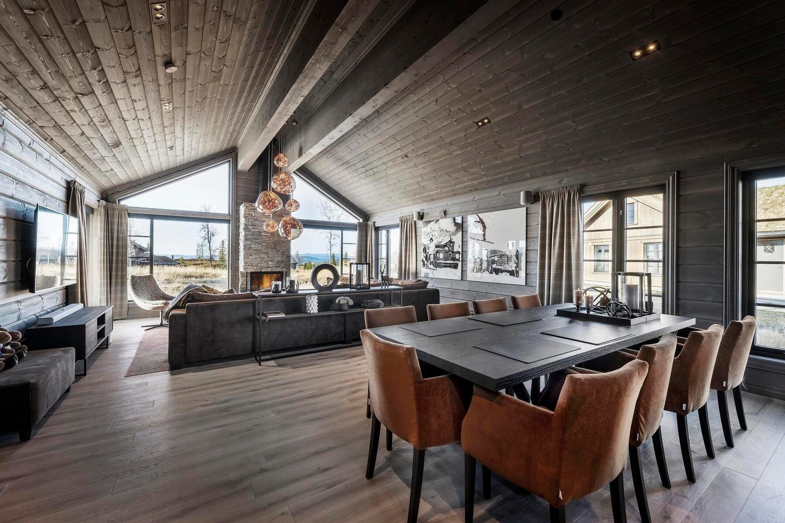 Peisen danner et midtpunkt i stuen mot panoramavinduene. Foto fra en tilsvarende hytte. Galleribilde