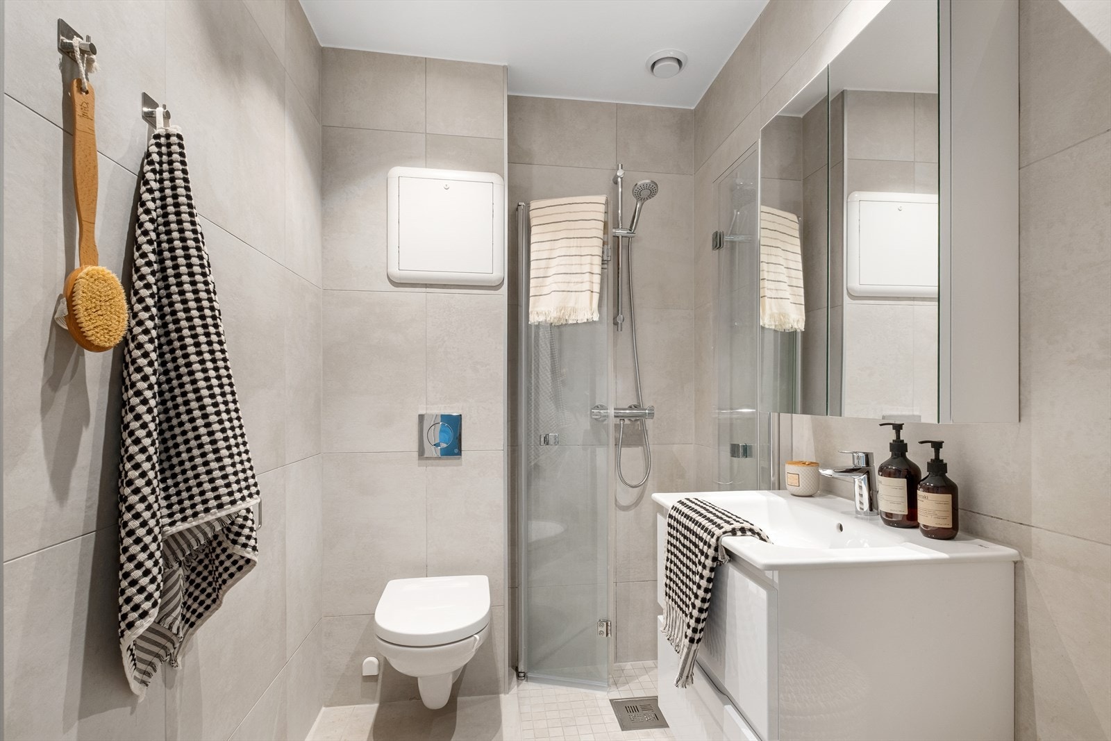 Pent flislagt bad fra 2022 med moderne fliskombinasjon. Badet har vegghengt toalett, dusj med innfellbare dusjvegger, servantinnredning med skuffer og veggmontert speilskap. Opplegg for vaskemaskin. Varmekabler i gulv. Galleribilde