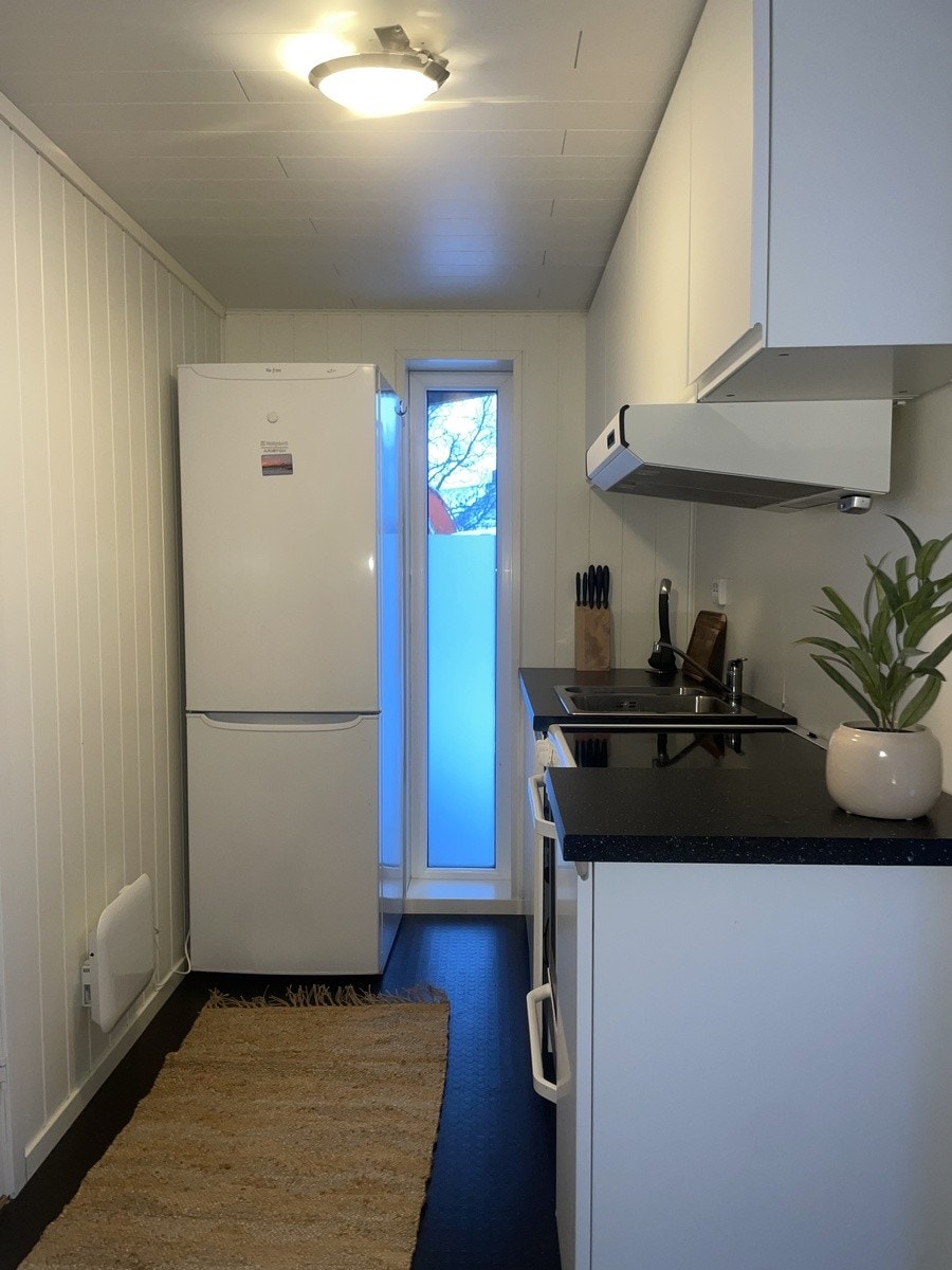 Kjøkken med komfyr, utstyr til bespisning, kasseroller, stekepanne, kjøl og frys. Galleribilde