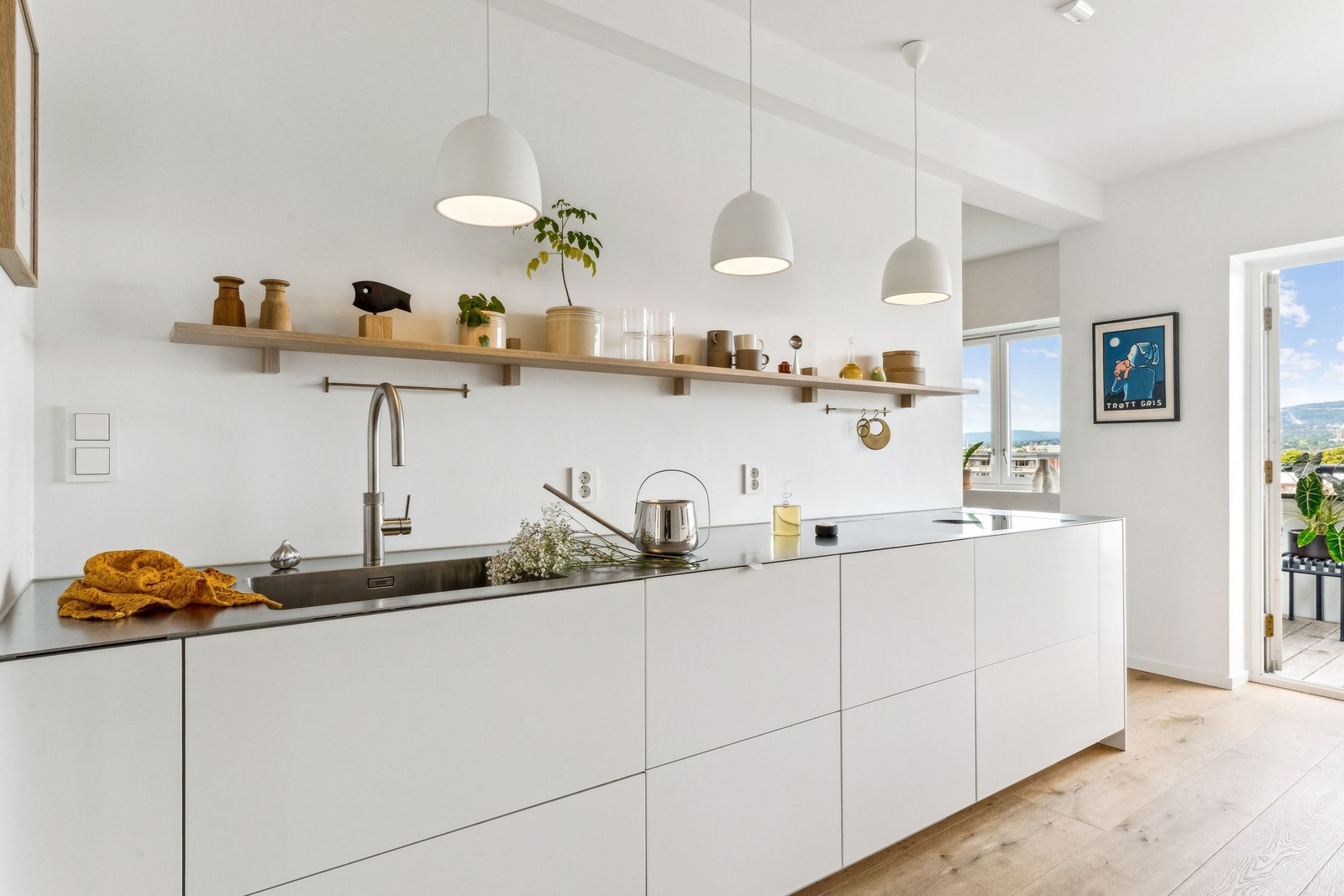 Benkeplaten i rustfritt stål glir sømløst over i en romslig vask. Kjøkkenkranen kan gi kokende vann til pastavann og kaffebrygging Galleribilde