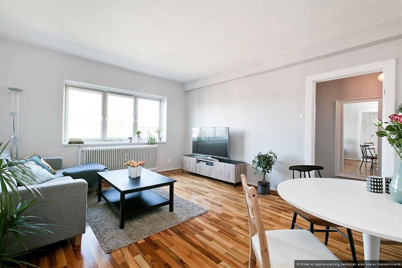 Lys og romslig stue som får rikelig med naturlig lys fra store vindusflater. Galleribilde