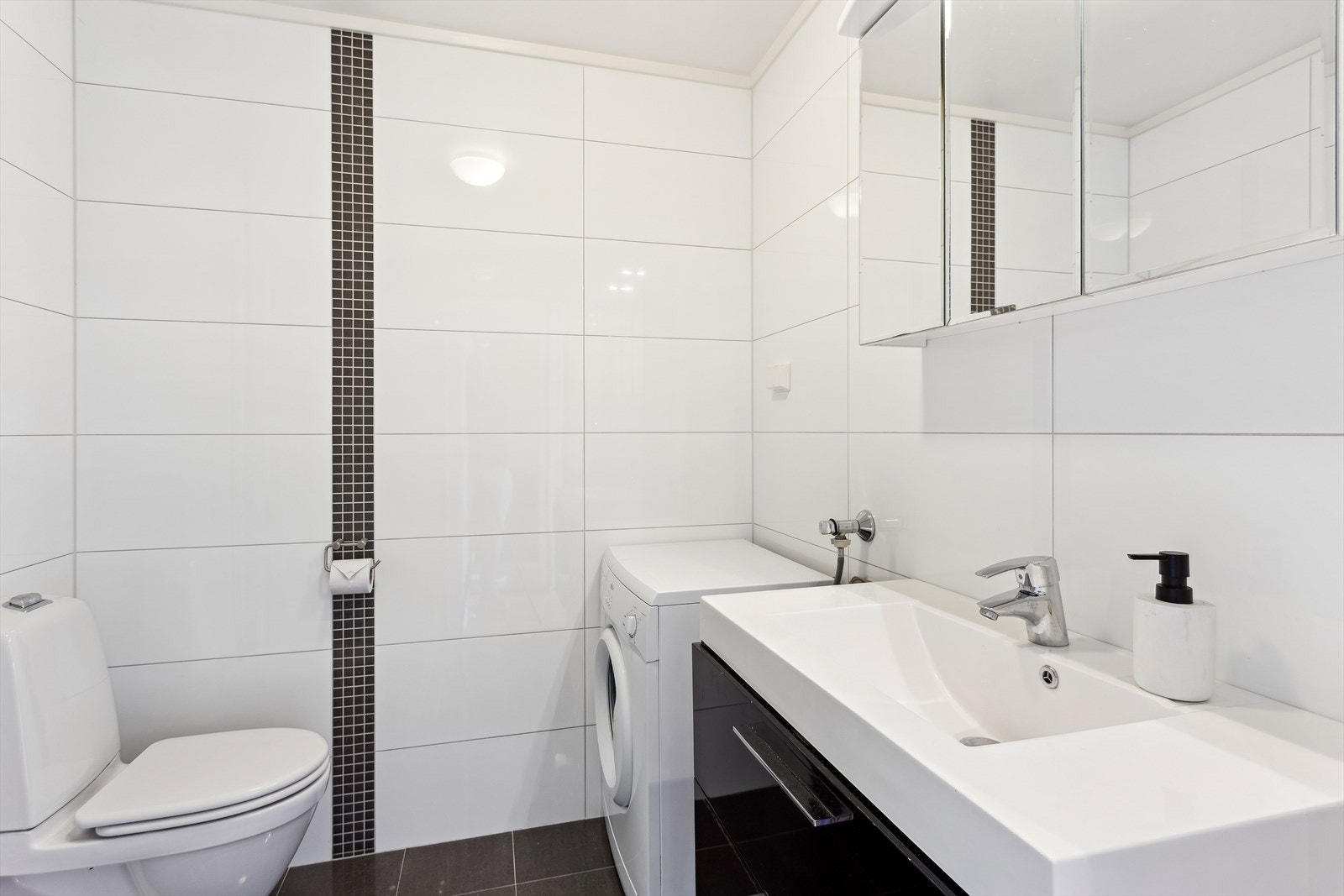 Delikat, flislagt baderom med gulvvarme og opplegg for vaskemaskin. Galleribilde