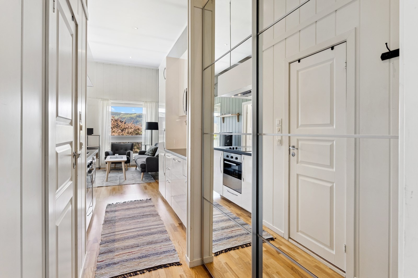 Velkommen hjem! Entré med god plass til yttertøy og sko i en praktisk skyvedørsgarderobe med speilfronter. Galleribilde