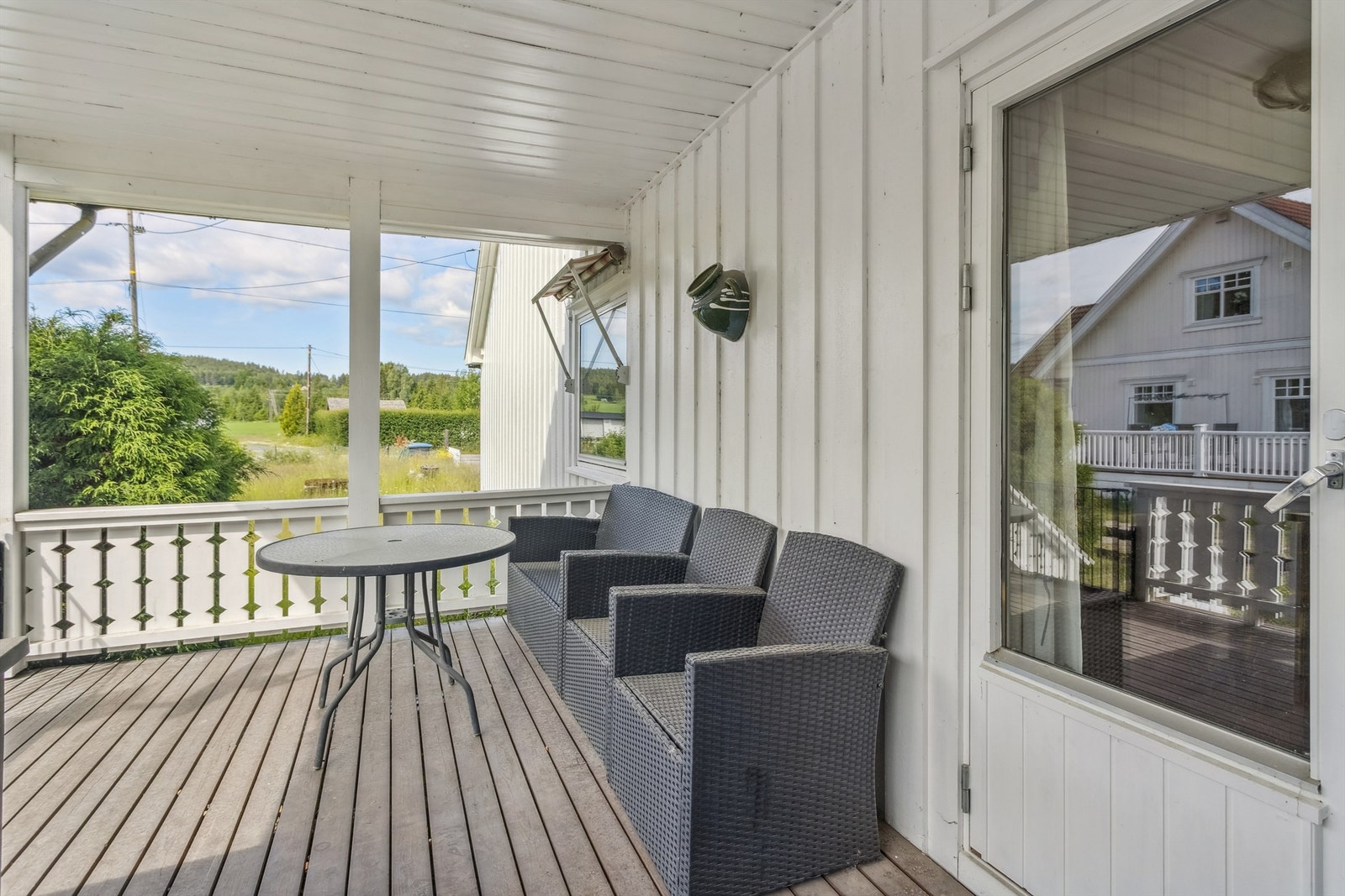 Sydvendt terrasse med impregnerte terrassebord og beiset rekkverk, ideell for avslapning utendørs. Utgang fra stuen. Galleribilde