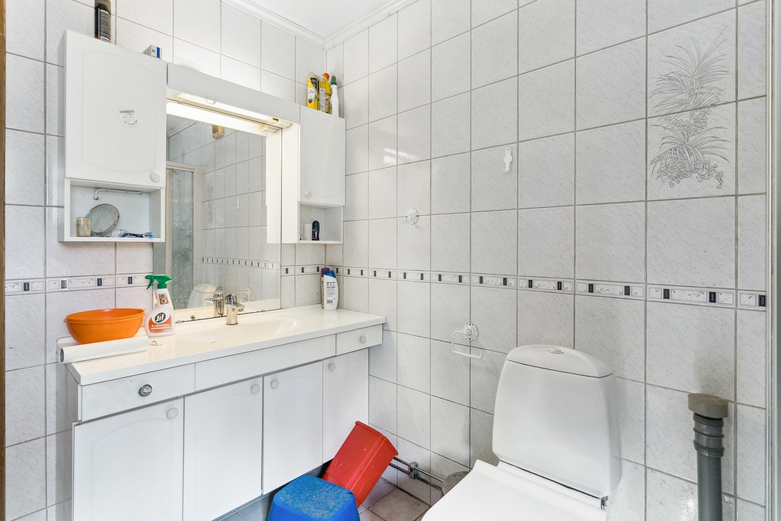 Eldre flislagt bad fra 1989. Badet har eldre innredning med servant og god oppbevaringsplass for toalettsaker. Galleribilde