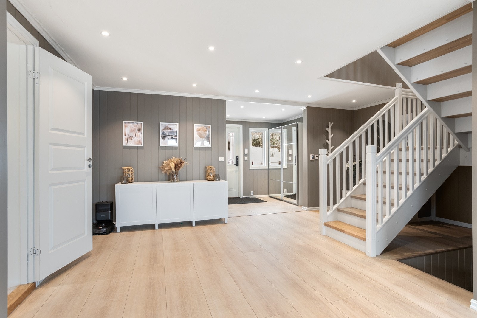 Stor og romlig hall med god plass til oppbevaring av familiens yttertøy. Skyvedørsgarderobe i entreen. Galleribilde