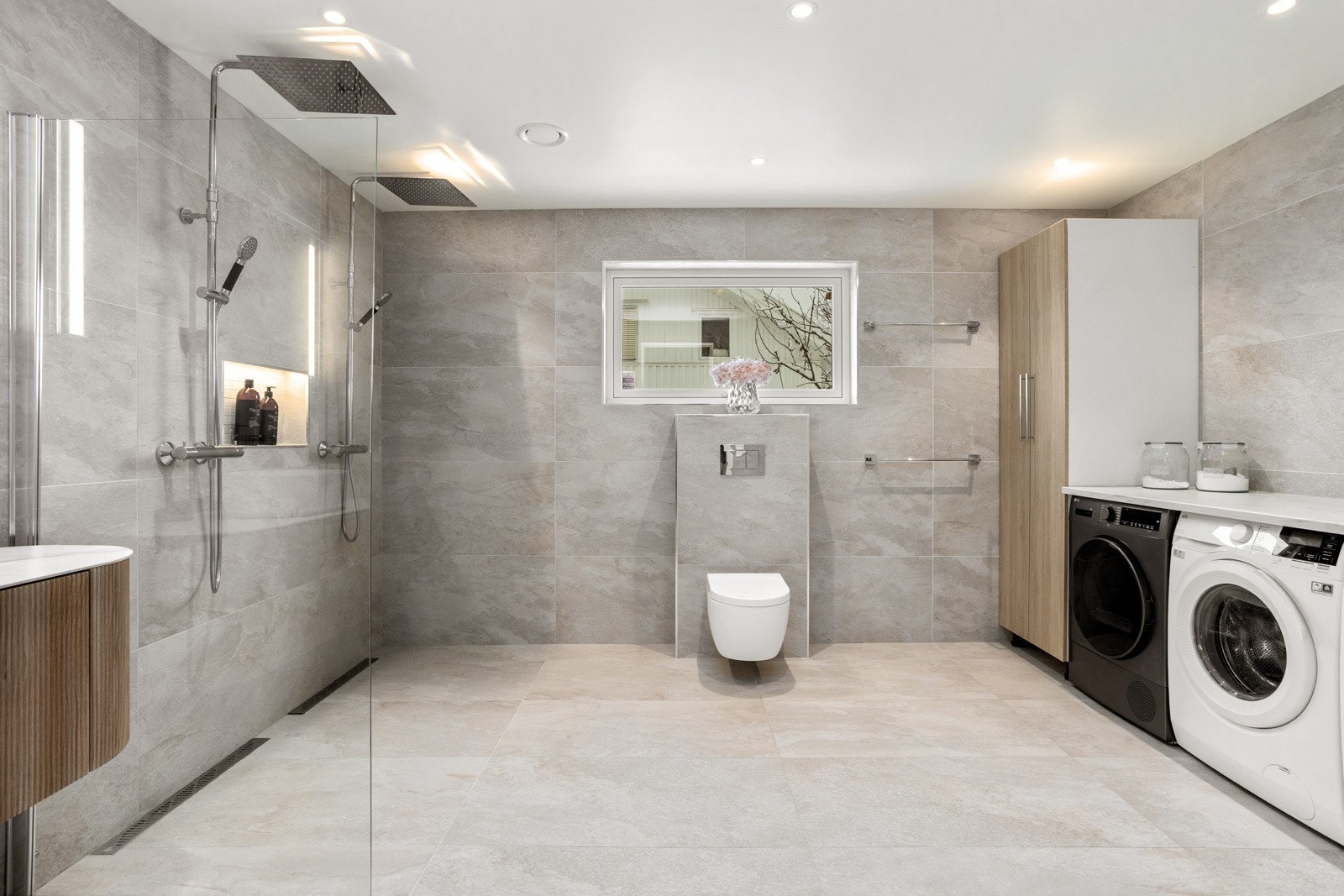 Stort og lekkert innredet baderom med doble regnfallsarmaturer og egen vaskesone - svært praktisk for familier. Galleribilde